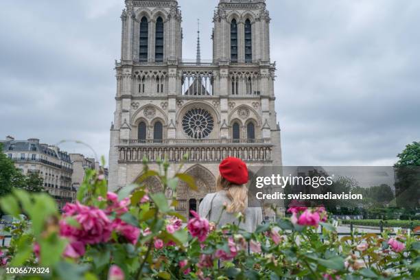 young woman in paris city travel contemplating the notre dame de paris cathedral in springtime - paris springtime stock pictures, royalty-free photos & images