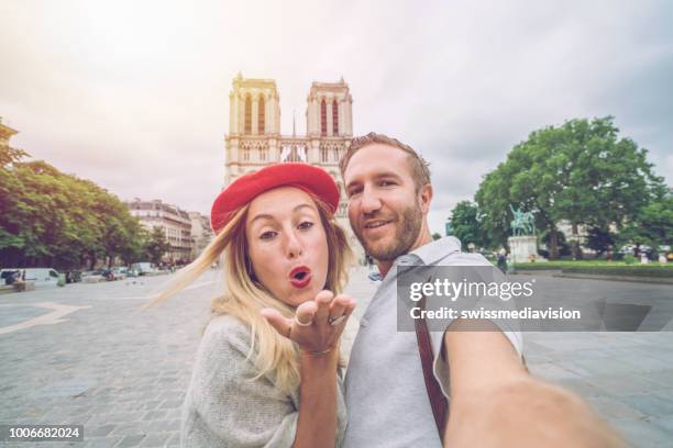 selfie portrait of young couple at notre dame de paris cathedral in paris, france; shot in the morning, travel people discovery city concept - paris summer stock pictures, royalty-free photos & images