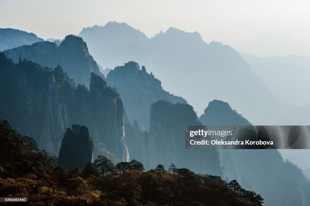 Sunset in the Huangshan Mountain Range - Anhui Province, China. Evening sun lights the cliffs below and observation deck.