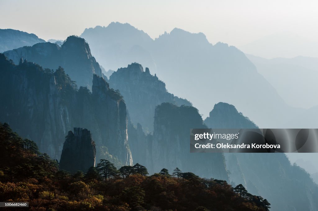 Sunset in the Huangshan Mountain Range - Anhui Province, China. Evening sun lights the cliffs below and observation deck.