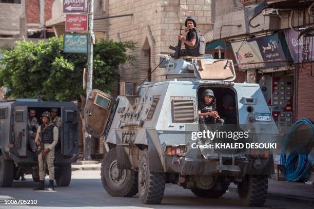 Picture taken on July 26, 2018 shows Egyptian policemen stand guarding a street in the North Sinai provincial capital of El-Arish. - With fruit and...