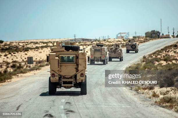 Picture taken on July 26, 2018 shows Egyptian policemen driving on a road leading to the North Sinai provincial capital of El-Arish. - With fruit and...