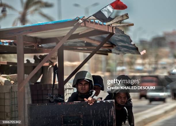 Picture taken on July 26, 2018 shows Egyptian policemen stand guarding a checkpoint on a road leading to the North Sinai provincial capital of...