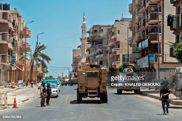 Picture taken on July 26, 2018 shows Egyptian policemen driving on a road leading to the North Sinai provincial capital of El-Arish. - With fruit and...