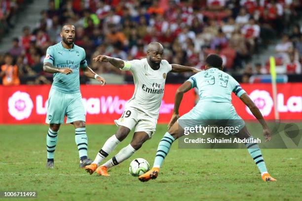 Lassana Diarra of Paris Saint Germain tries tio dribble past Joe Willock of Arsenal during the International Champions Cup match between Arsenal and...