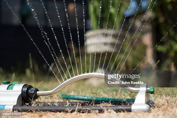 Water sprays from a sprinkler in a garden on July 24, 2018 in Leigh On Sea, England. Seven million residents in the north west of England are...