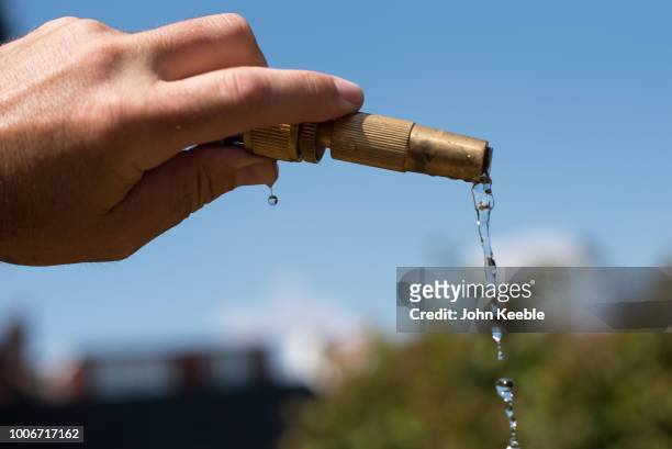 Water trickles from a hosepipe as a man waters a garden on July 24, 2018 in Leigh On Sea, England. Seven million residents in the north west of...