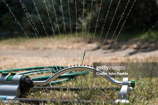 Water sprays from a sprinkler in a garden on July 24, 2018 in Leigh On Sea, England. Seven million residents in the north west of England are...