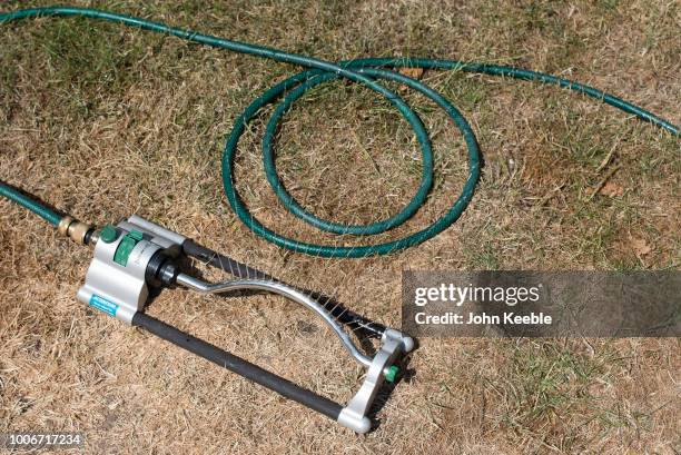 Water sprays from a sprinkler in a garden on July 24, 2018 in Leigh On Sea, England. Seven million residents in the north west of England are...