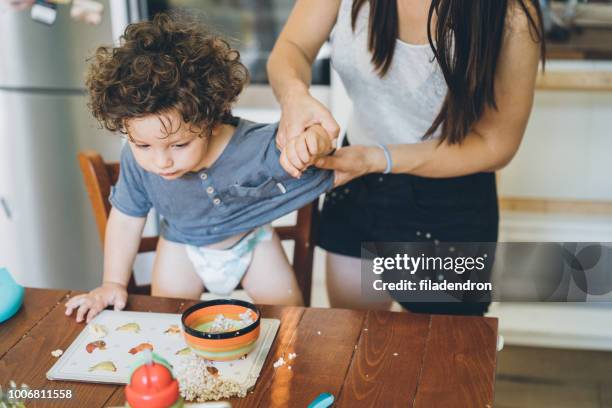 mother make the mess after toddler lunch - messy table stock pictures, royalty-free photos & images