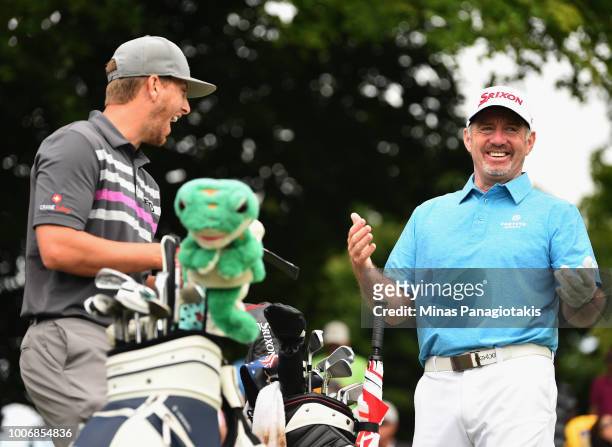 Rod Pampling of Australia and Chris Stroud share a laugh on the first tee during the third round at the RBC Canadian Open at Glen Abbey Golf Club on...