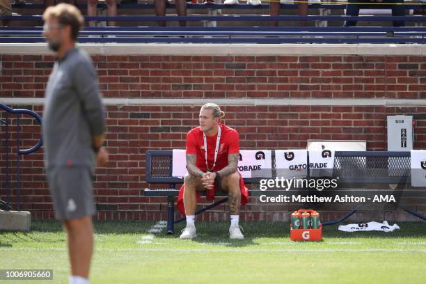Jurgen Klopp the head coach / manager of Liverpool stands with goalkeeper Loris Karius sitting alone on a bench and not in the team prior to the...