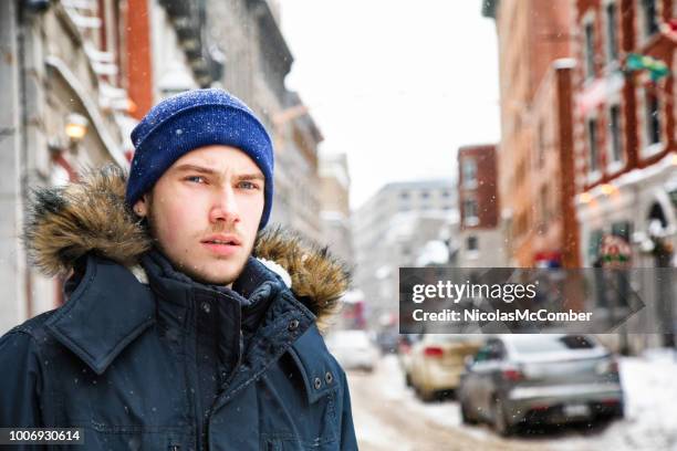 男性のティーンエイ ジャーのルックスを離れて古いモントリオールの雪嵐の中心配してください。 - canada christmas ストックフォトと画像