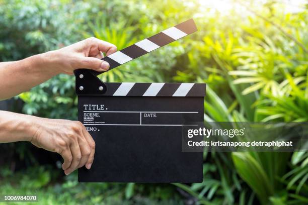 a man holding movie clapper. - film slate photos et images de collection