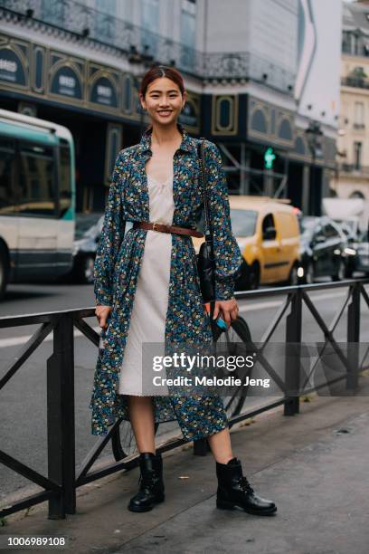 Korean model Hoyeon Jung wears a a blue floral H&M dress-shirt, pink slip dress, leather belt, black Chanel bag, and black boots after the...