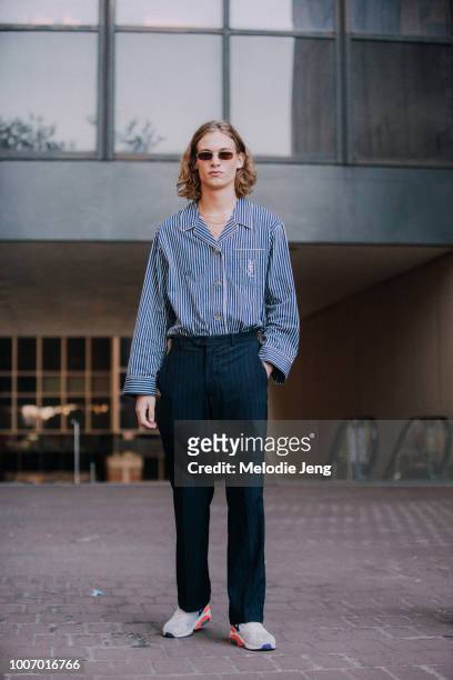 Model Simon Fakkert wears a blue striped YSL shirt, blue pants, and Nike sneakers during New York Fashion Week Men’s Spring/Summer 2019 on July 9,...
