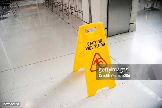 yellow sign wer floor on the ground - hazardous workplace stock-fotos und bilder
