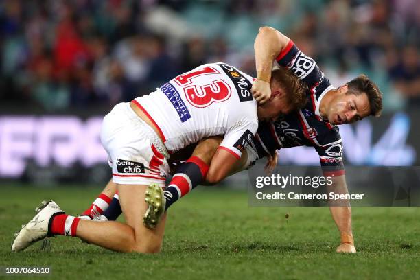 Cooper Cronk of the Roosters is tackled by Jack de Belin of the Dragons during the round 20 NRL match between the Sydney Roosters and the St George...