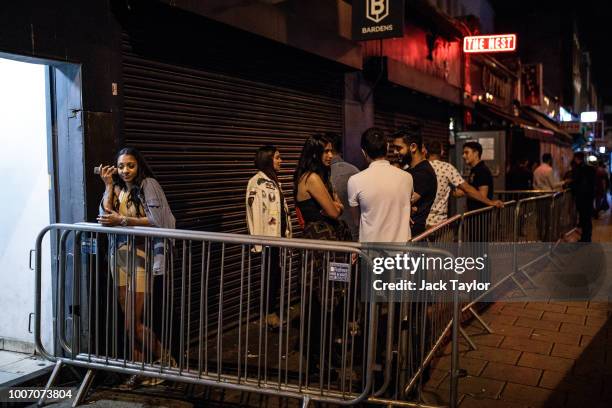 Revellers gather in the smoking area outside the Nest nightclub in Dalston, the weekend before new licensing rules come in to effect across Hackney...