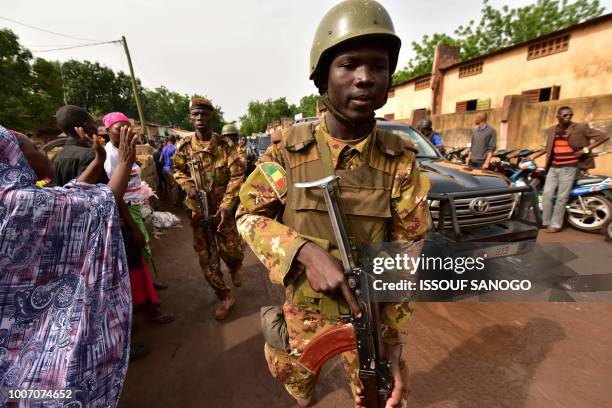 Soldiers escort Malian outgoing president Ibrahim Boubacar Keita convoy leaving after casting his vote in a polling station in Bamako on July 29,...