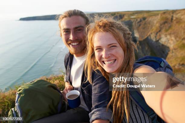 young happy hiking couple taking self portrait on an atlantic coastline. - dougal waters ��個照片及圖片檔