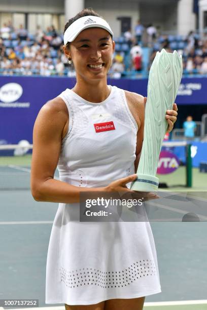 Wang Qiang of China holds the winner's trophy after her women's singles final match against compatriot Zheng Saisai at the Jiangxi Open tennis...