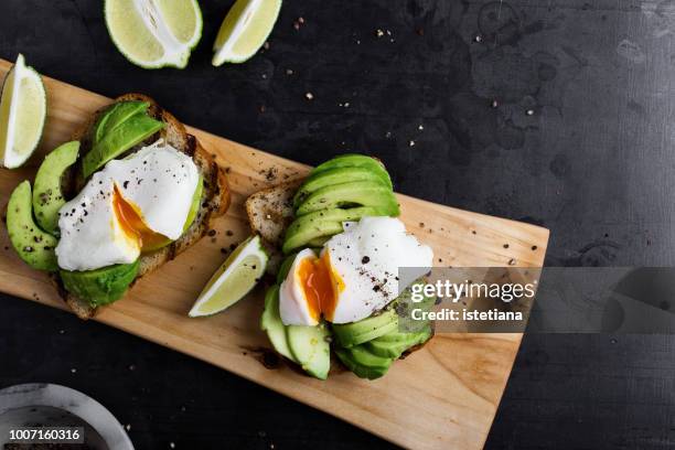 vegetarian sandwiches with poached egg and sliced avocado - avocado stock-fotos und bilder