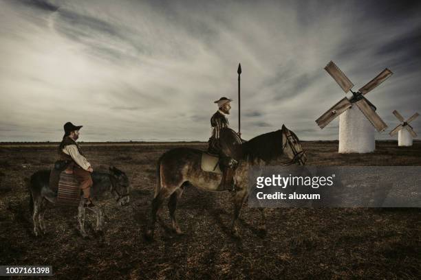 don quijote y sancho panza montando a través de campos de la mancha españa - don quijote de la mancha fotografías e imágenes de stock