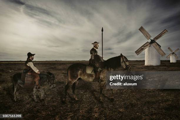 don quixote en sancho panza die door de velden rijden in la mancha-spanje - don quixote stockfoto's en -beelden