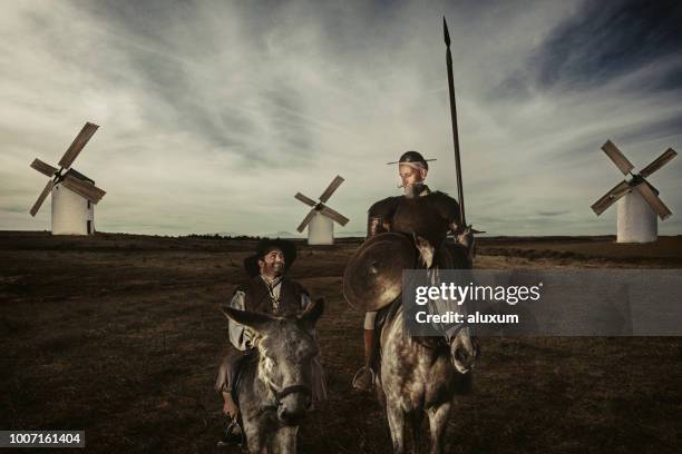 don quixote and sancho panza riding through fields in la mancha spain - squire stock pictures, royalty-free photos & images