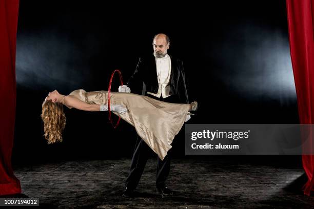 magician performing levitation trick on stage - sorcerer imagens e fotografias de stock