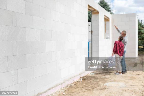 couple on construction site of new house - dreams foundation stock pictures, royalty-free photos & images