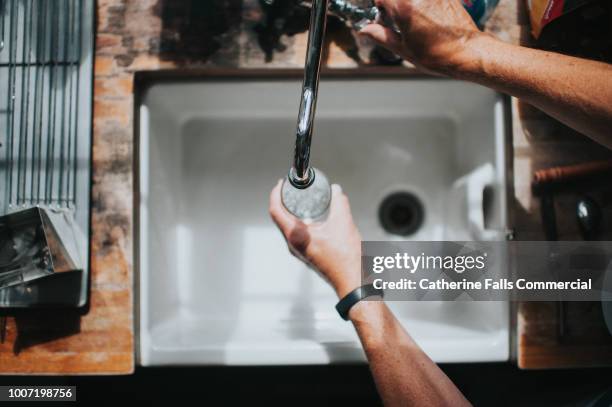 belfast sink with running water tap - tap water stock-fotos und bilder