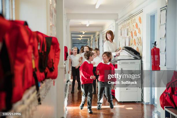 grundschulkinder laufen durch den korridor - kopiergerät stock-fotos und bilder