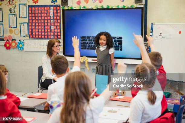 presenting to her classmates with her teacher - interactive workbook stock pictures, royalty-free photos & images