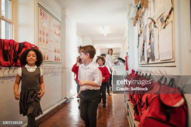 elementary school children walking through the corridor - british culture walking stock pictures, royalty-free photos & images