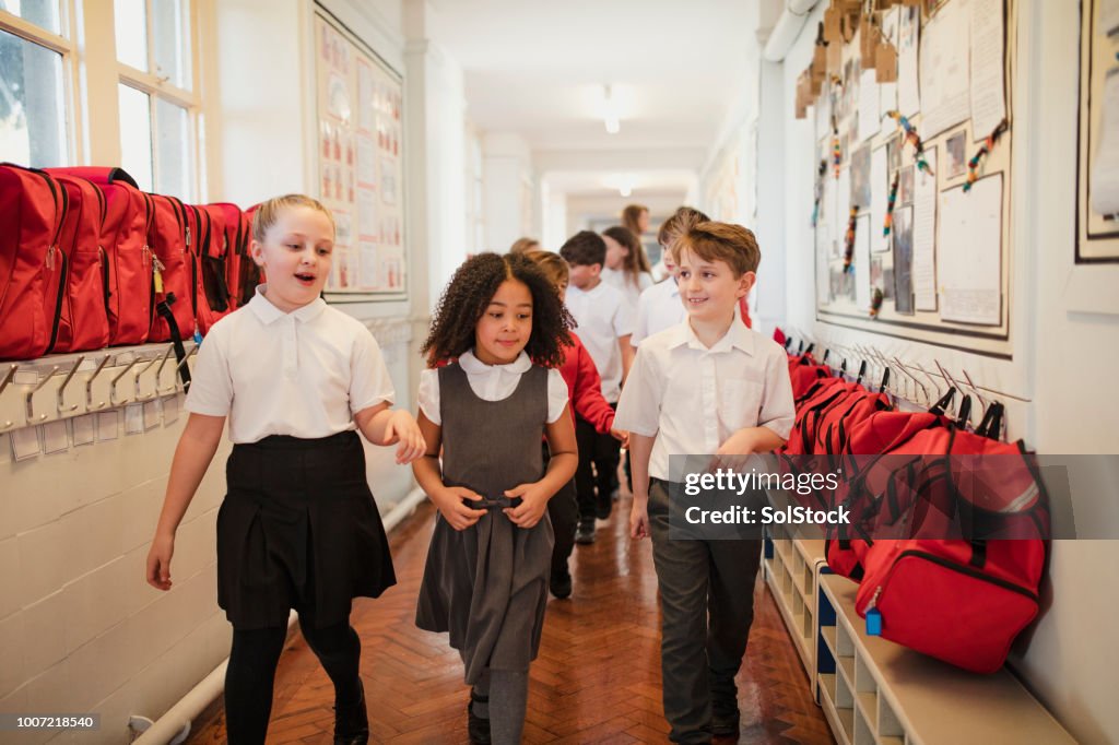 School Children Walk Through the Corridor