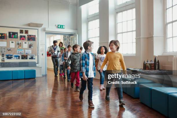 elementary school children walking through the hall - school-assembly-hall stock pictures, royalty-free photos & images