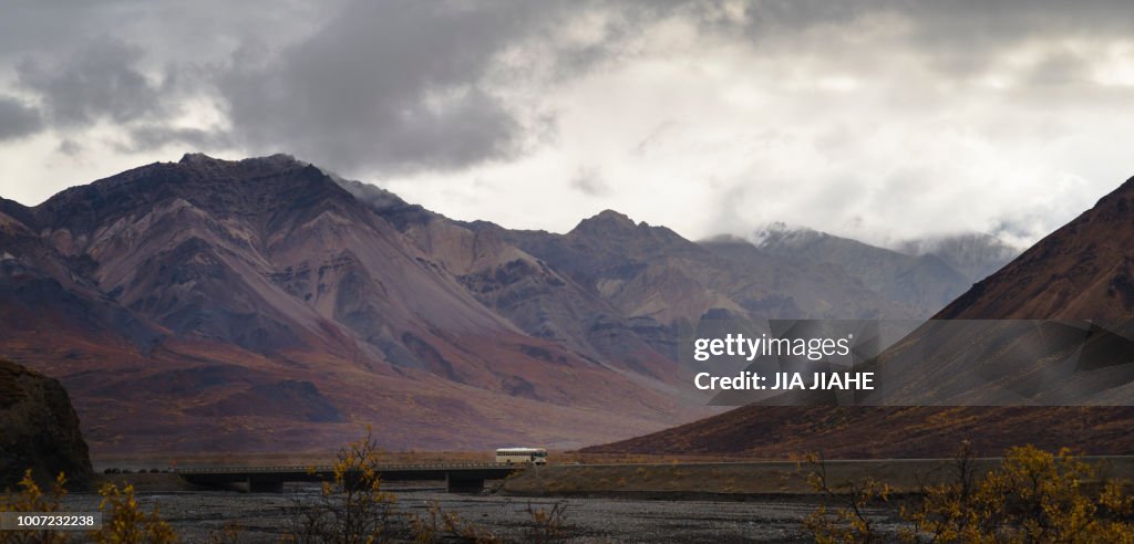 Tourist bus driving among mountains in the Denali National Park, Alaska, United States of America, North America