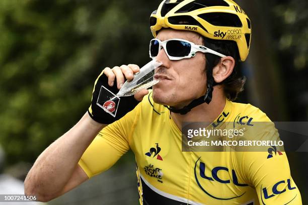Great Britain's Geraint Thomas, wearing the overall leader's yellow jersey, drinks champagne during the 21st and last stage of the 105th edition of...