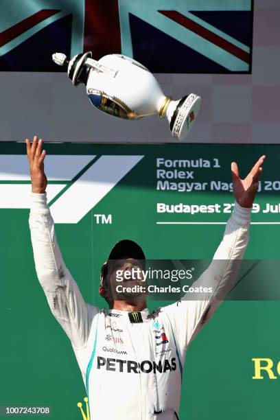 Race winner Lewis Hamilton of Great Britain and Mercedes GP celebrates with his trophy on the podium during the Formula One Grand Prix of Hungary at...