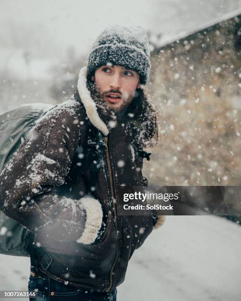 young man walking in the snow - sheepskin stock pictures, royalty-free photos & images