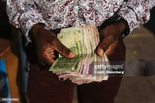 Man holds Zimbabwean dollar bond banknotes for an arranged photograph in Bindura, Zimbabwe on Sunday, July 29, 2018. Zimbabweans will elect a new...