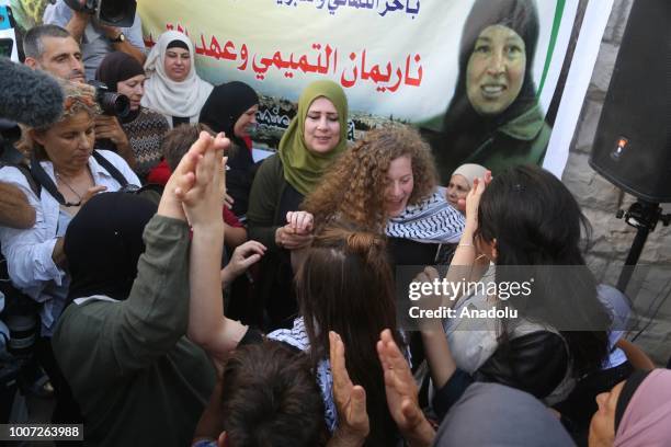 Palestinian teenager Ahed al-Tamimi and her mother Nariman Tamimi are welcomed by press members and citizens at the entrance of in Nabi Salih village...