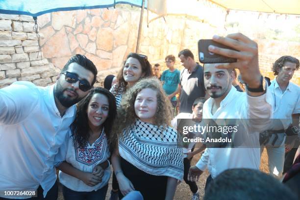 Palestinian teenager Ahed al-Tamimi and her mother Nariman Tamimi are welcomed by press members and citizens at the entrance of in Nabi Salih village...