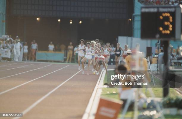 Zola Budd of Great Britain leads as Mary Decker of the United States trips and crashes out of the race during competition in the final of the Woman's...