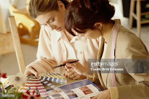 two women at home working on interior decorations - designer de interiores - fotografias e filmes do acervo