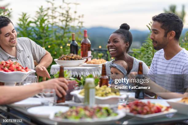 eine gruppe von jungen erwachsenen freunden essen im freien auf der terrasse - filipino family dinner stock-fotos und bilder