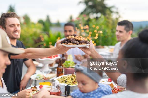 eine gruppe von jungen erwachsenen freunden essen im freien auf der terrasse - filipino family dinner stock-fotos und bilder