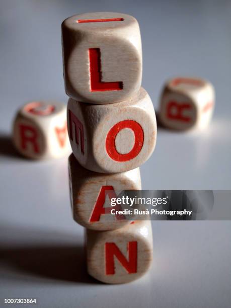 white and orange scrabble dice spelling the word "loan" - money borrow stockfoto's en -beelden